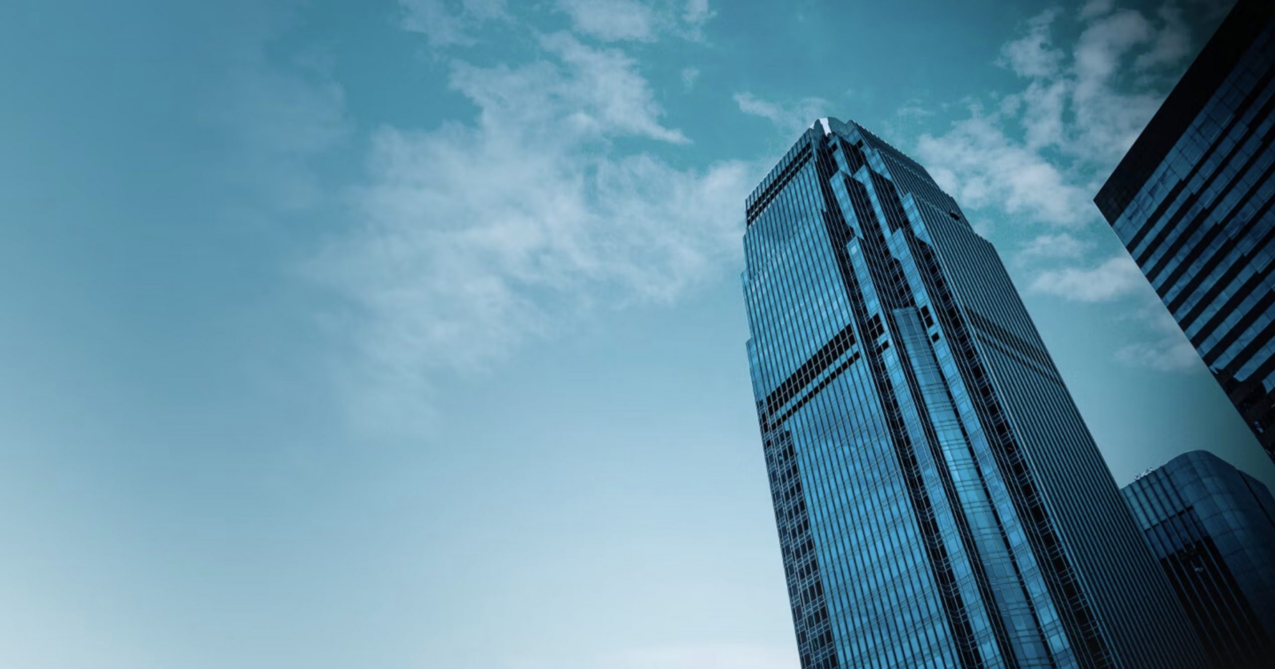 Upshot of a skyscraper against a green-blue sky
